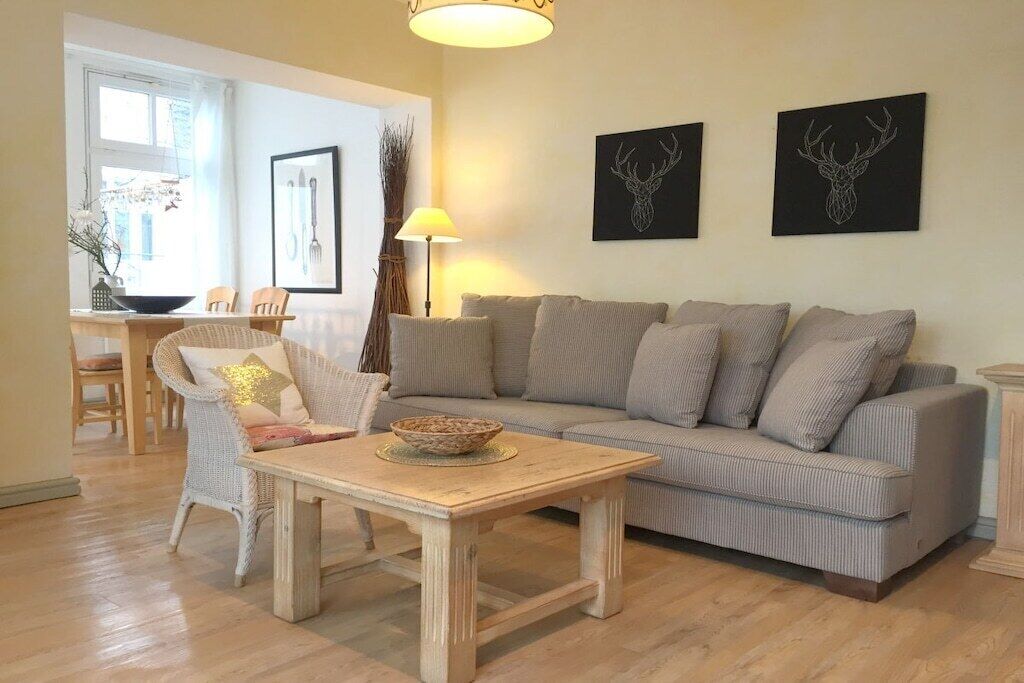 A living room with a sofa, a table, and two wall-mounted deer antler artworks.