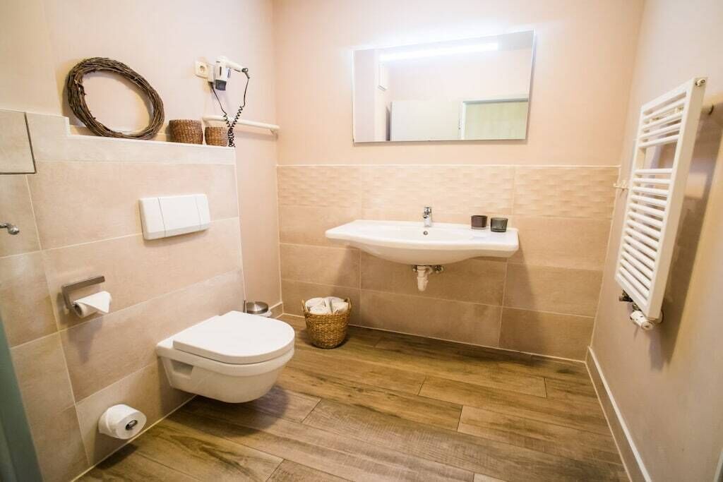 Een badkamer met toilet, wastafel en spiegel.