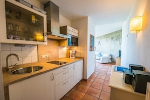 A compact kitchen with a sink, cabinets, and a coffee maker. - Tower House Holiday Apartment 4 (Kühlungsborn)