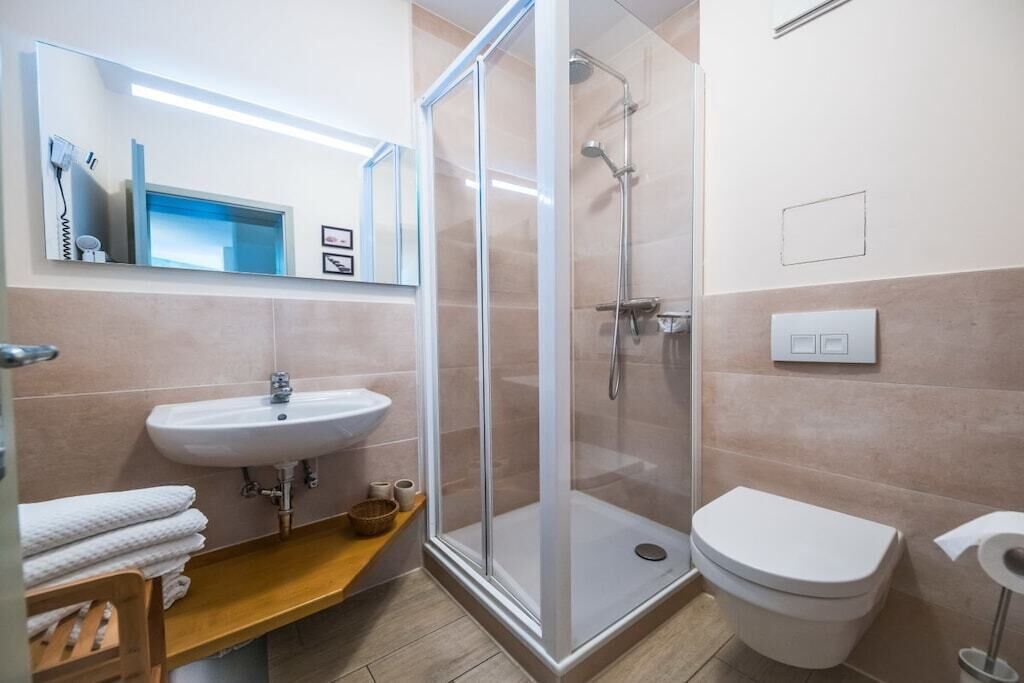 Ein Badezimmer mit Duschkabine, Waschbecken und Toilette.
