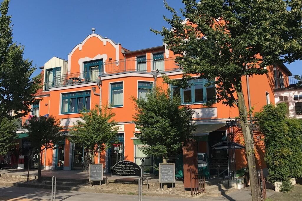 Un edificio de varios pisos con balcones y un cartel al frente.