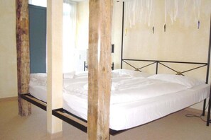 A room with a bed, wooden beams, and a metal headboard. - Tower House Holiday Apartment 11 (Kühlungsborn)