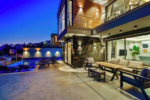 A modern outdoor patio with a pool, lounge chairs, and a dining area. - Walk Distance to the Town (Kaş)
