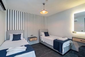 A hotel room with two beds, a nightstand, a dresser, and a mirror. - Walk Distance to the Town (Kaş)