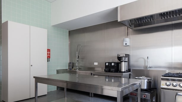 Una cucina moderna con elettrodomestici in acciaio inossidabile, una macchina da caffè e un fornello a gas.