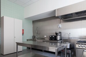 A modern kitchen with stainless steel appliances, a coffee machine, and a gas stove.