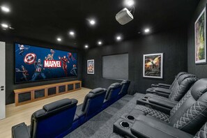 A home theater with a large flat-screen TV, black leather reclining seats, and a wooden entertainment unit. - Villa Spectacular - Luxury Hilltop Estate | Wine Country Views (Temecula)