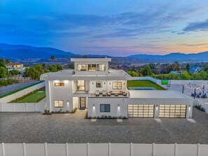 A modern two-story house with a flat roof, large windows, and a garage. - Villa Spectacular - Luxury Hilltop Estate | Wine Country Views (Temecula)