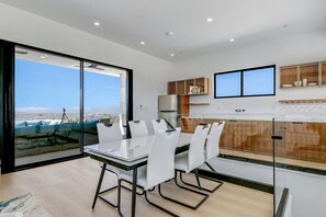 Una cocina moderna con comedor, ventanas amplias y vista a la ciudad.
