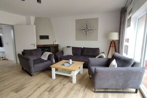 Ein modernes Wohnzimmer mit einer Sofagarnitur, einem Couchtisch und einer Lampe.