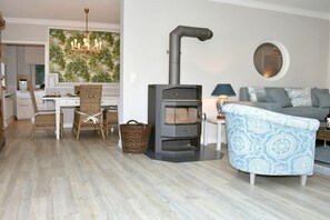 A living room with a sofa, a table with a lamp, and a wood-burning stove. - at the sailing school (Heiligenhafen)