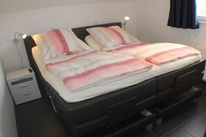 A bed with a black headboard and two bedside lamps. - Holiday apartment with 2 bedrooms (Wendisch Rietz)