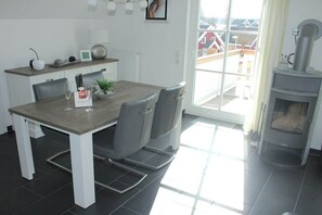 A dining area with a table, chairs, a window, and a fireplace.