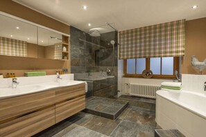 Un bagno moderno con doppio lavabo, cabina doccia in vetro e termosifone.