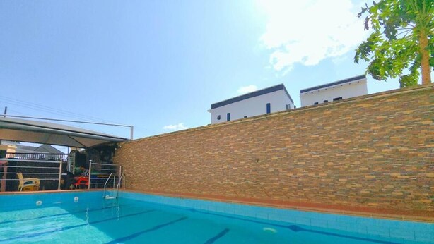 Una piscina amb mur de maó i zona coberta.