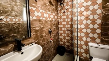 Une salle de bain avec un lavabo, des toilettes et une douche.