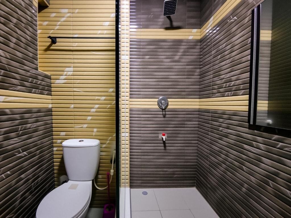 Un baño con inodoro, ducha y lavamanos.
