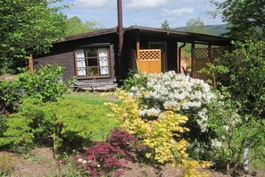 A wooden cabin with a garden in front, a wooden fence, and a clear sky. - Holiday home Berghaus (Reinhardshagen)