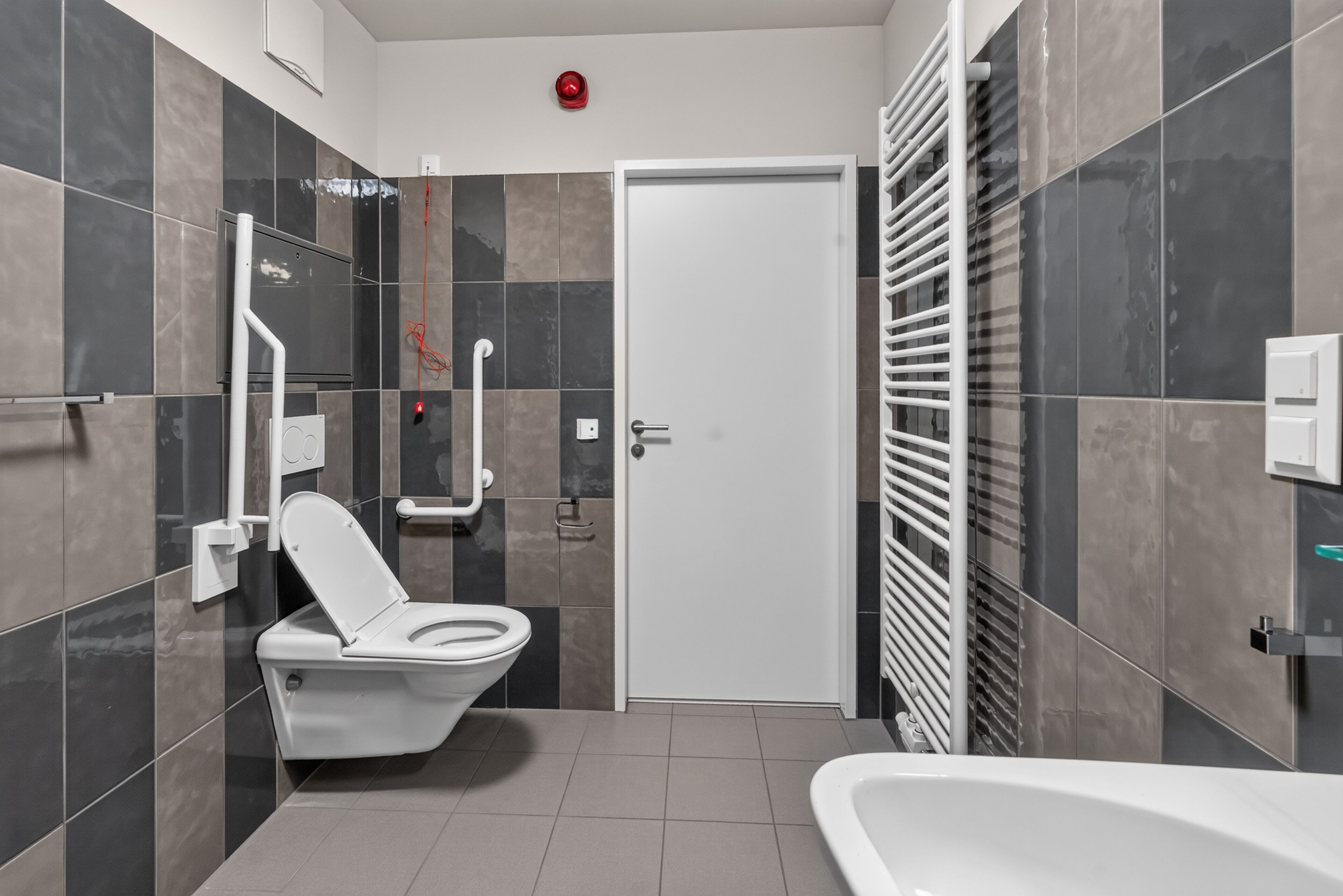 A modern bathroom with a toilet, bidet, and bathtub.