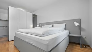 Un dormitorio moderno con una cama grande, mesitas de noche y un armario.