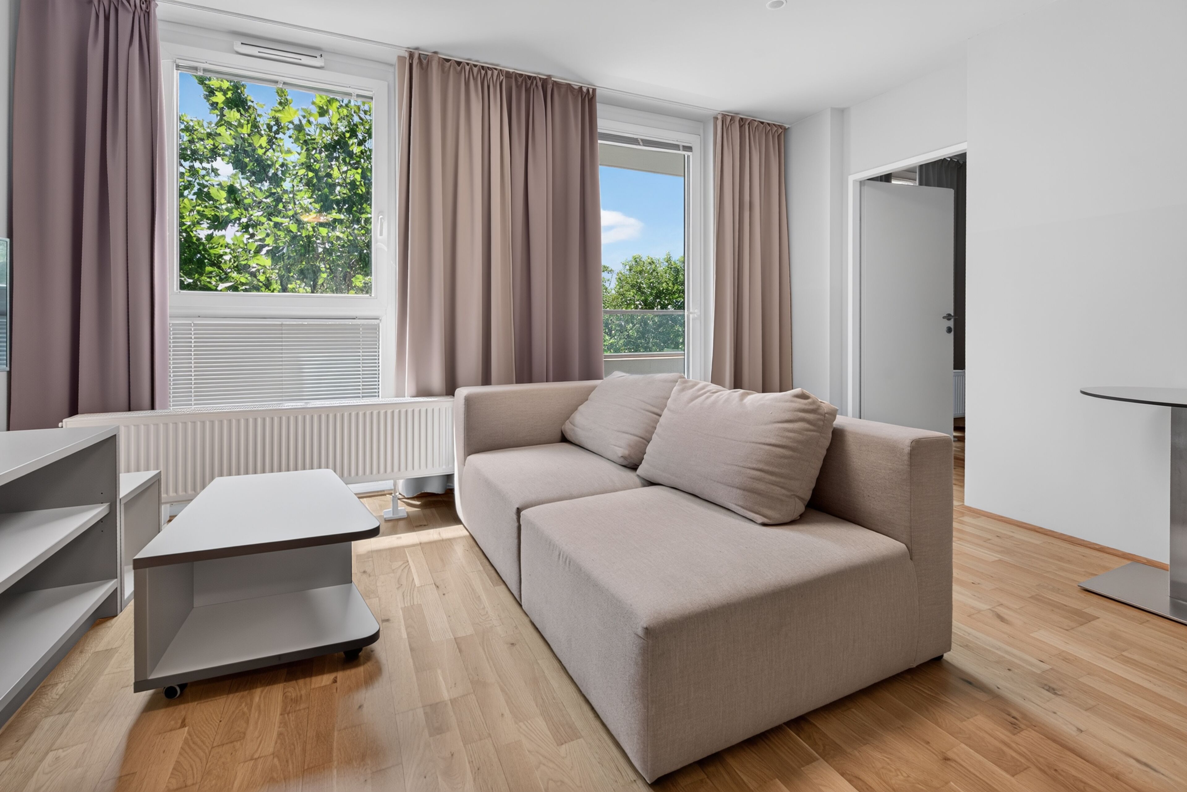 A modern living room with a sofa, a table, and a radiator.