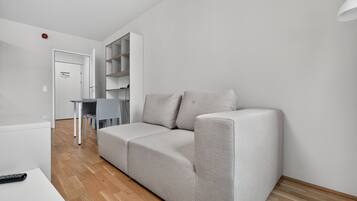 A modern living room with a grey sofa, a small table, and a white cabinet.