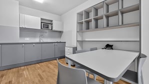 Una cocina moderna con armarios grises, un microondas y un horno empotrado.
