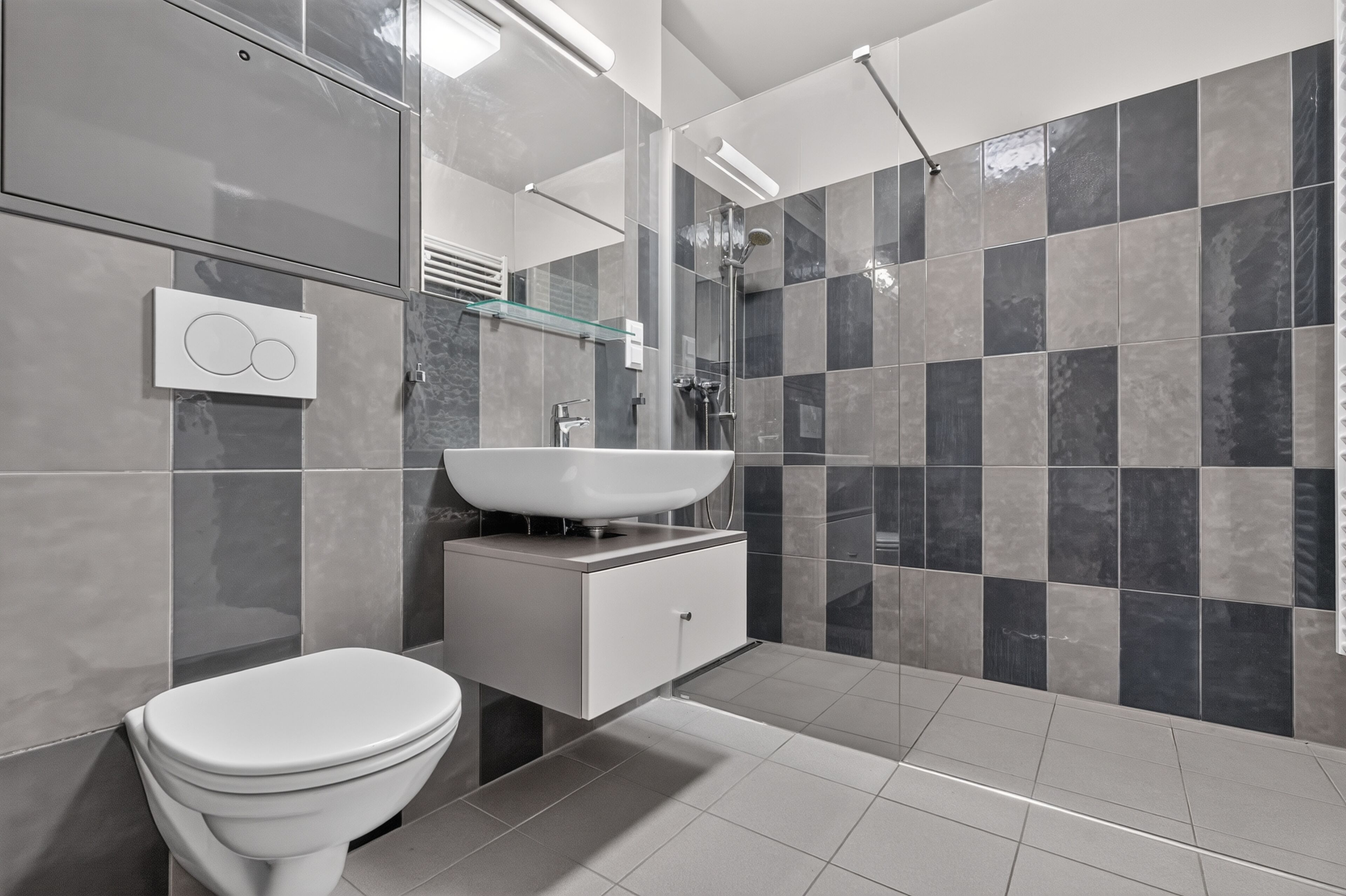 A modern bathroom with a toilet, sink, and shower.