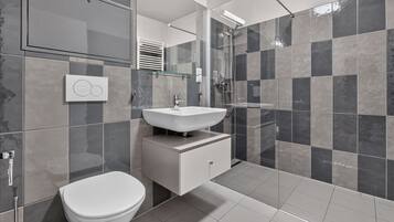 Un baño moderno con inodoro, lavabo y ducha.