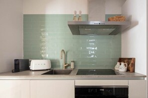 A kitchen with a sink, a toaster, and a dishwasher. - Seehaus Allensbach “Water Lily Suite” (Allensbach)