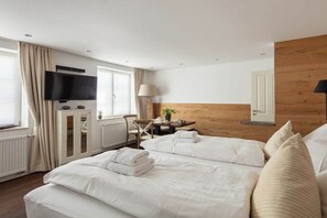 A hotel room with a bed, a desk, a chair, a television, and a window with curtains. - Seehaus Allensbach “Water Lily Suite” (Allensbach)