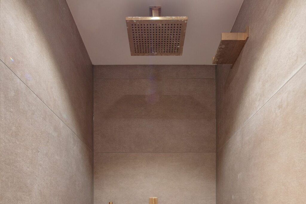 A modern bathroom with a large, square showerhead and a minimalist design.