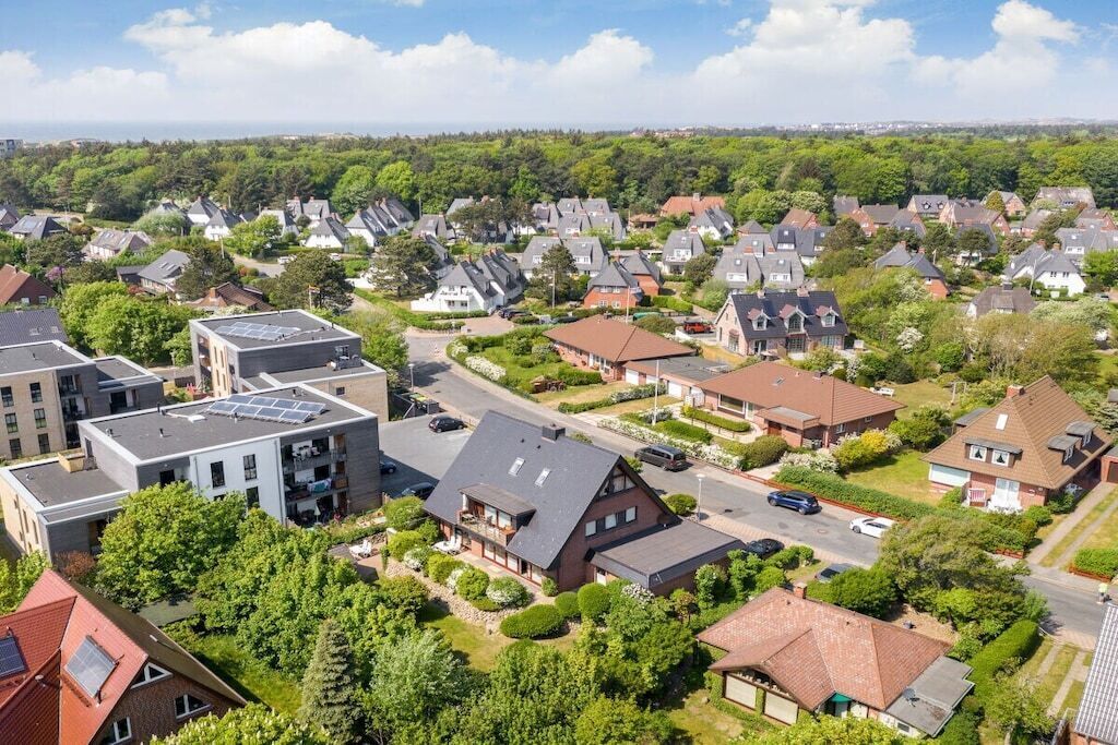 Un quartier résidentiel avec des maisons, des rues et des espaces verts.