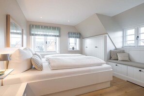 Un dormitorio con una cama, un banco y un armario.