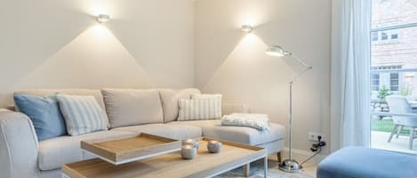 A modern living room with a sofa, coffee table, and floor lamp.