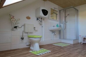 Un baño con inodoro, bidé, lavabo y ducha.