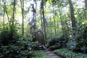 A forested area with a stone monument featuring a carved face. - Holiday apartment in Teltow with Wi-Fi (Teltow)