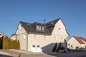 A two-story house with a garage, a sloped roof, and a chimney. - Seehaus Allensbach “Ocean Suite” (Allensbach)