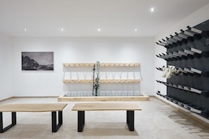 A minimalist room with two wooden tables, a ski rack, and a framed picture on the wall. - WALDECK in the CHALET ZUGSPITZEREI (Grainau)