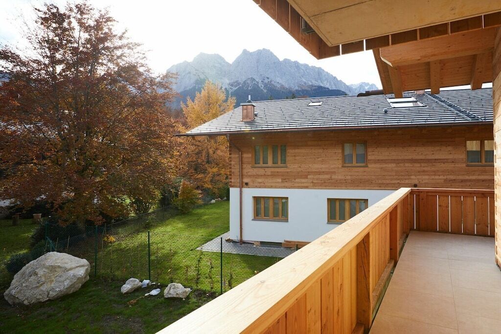 A wooden cabin with a balcony overlooking a mountainous landscape.