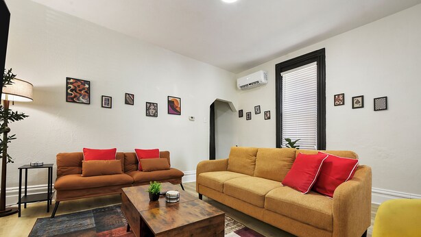 A living room with two sofas, a coffee table, and a yellow armchair. - Funky 3-bedroom - 5 min walk to Grandview Overlook (Pittsburgh)