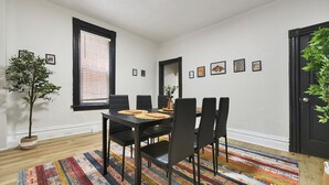 A dining area with a black table, chairs, and a colorful rug. - Funky 3-bedroom - 5 min walk to Grandview Overlook (Pittsburgh)