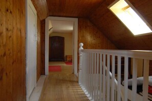 A wooden interior with a sloped ceiling, a white railing, and a skylight. - Holiday home with 3 bedrooms (Dufftown \/ Glennrinnes)