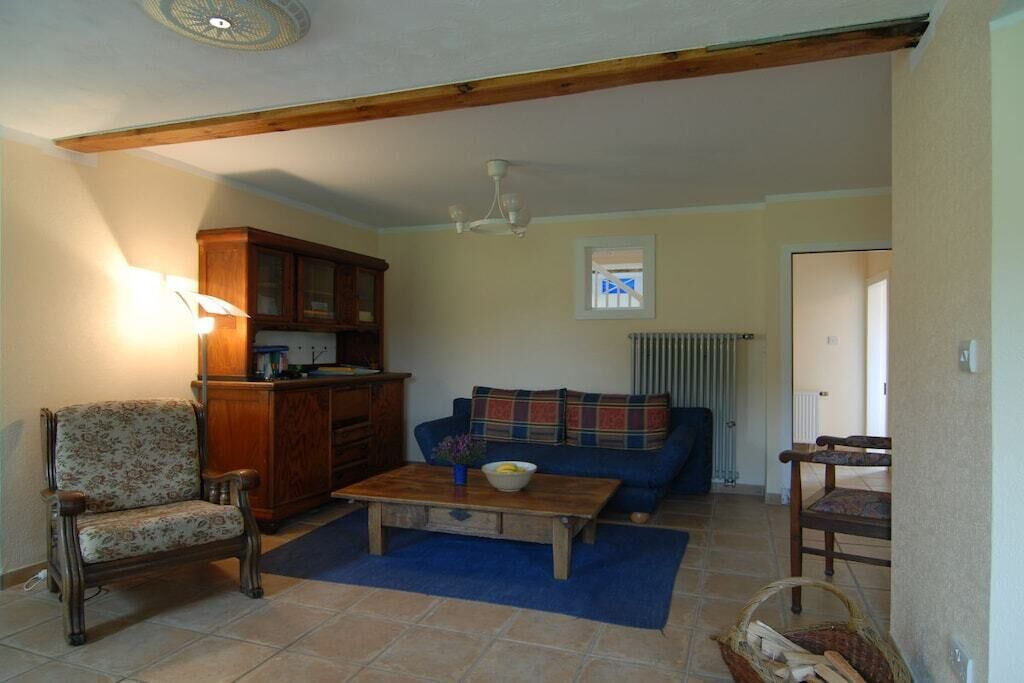 A living room with a sofa, a wooden coffee table, a chair, and a cabinet.
