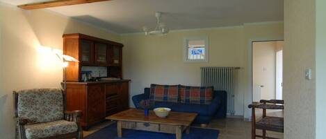 A living room with a sofa, a wooden coffee table, a chair, and a cabinet.
