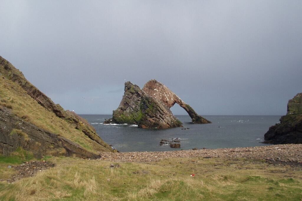 A coastal landscape with a prominent rock formation.