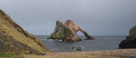 A coastal landscape with a prominent rock formation.