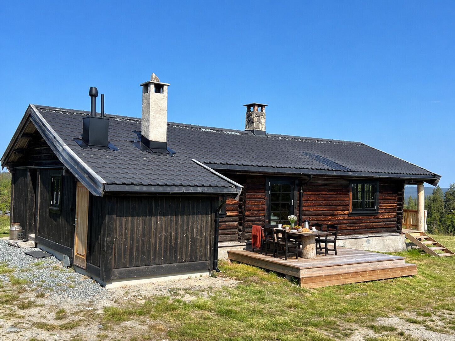 Une cabane en rondins avec une terrasse et une cheminée.