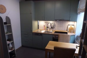A compact kitchen with a sink, countertop, and a clock on the wall. - Holiday apartment with 1 bedroom (Lübeck)