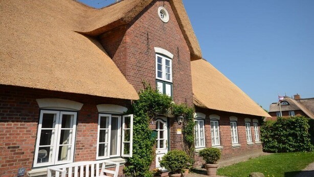 A traditional brick building with a thatched roof and white-framed windows. - Holiday home in Alkersum with swimming pool (Alkersum)